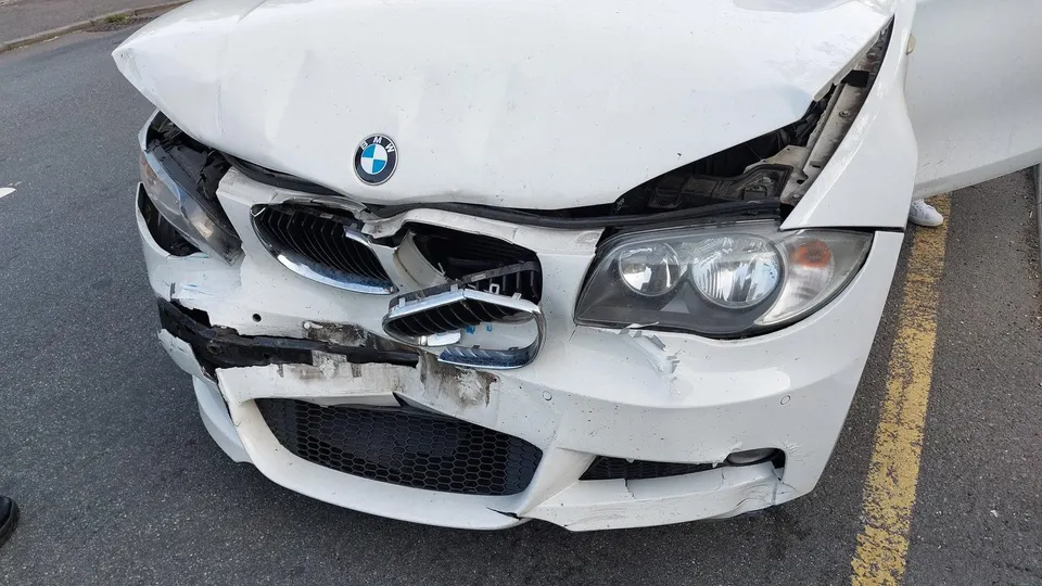 Baltas BMW su apdaužytu priekiu